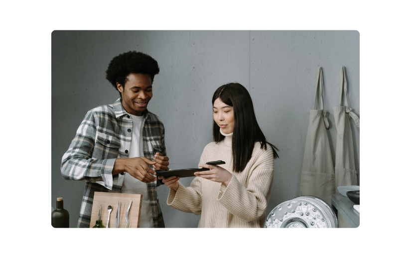 Deux personnes examinent les options de produits sur une tablette, soulignant la nécessité de la meilleure plateforme de commerce électronique pour les ventes en ligne.